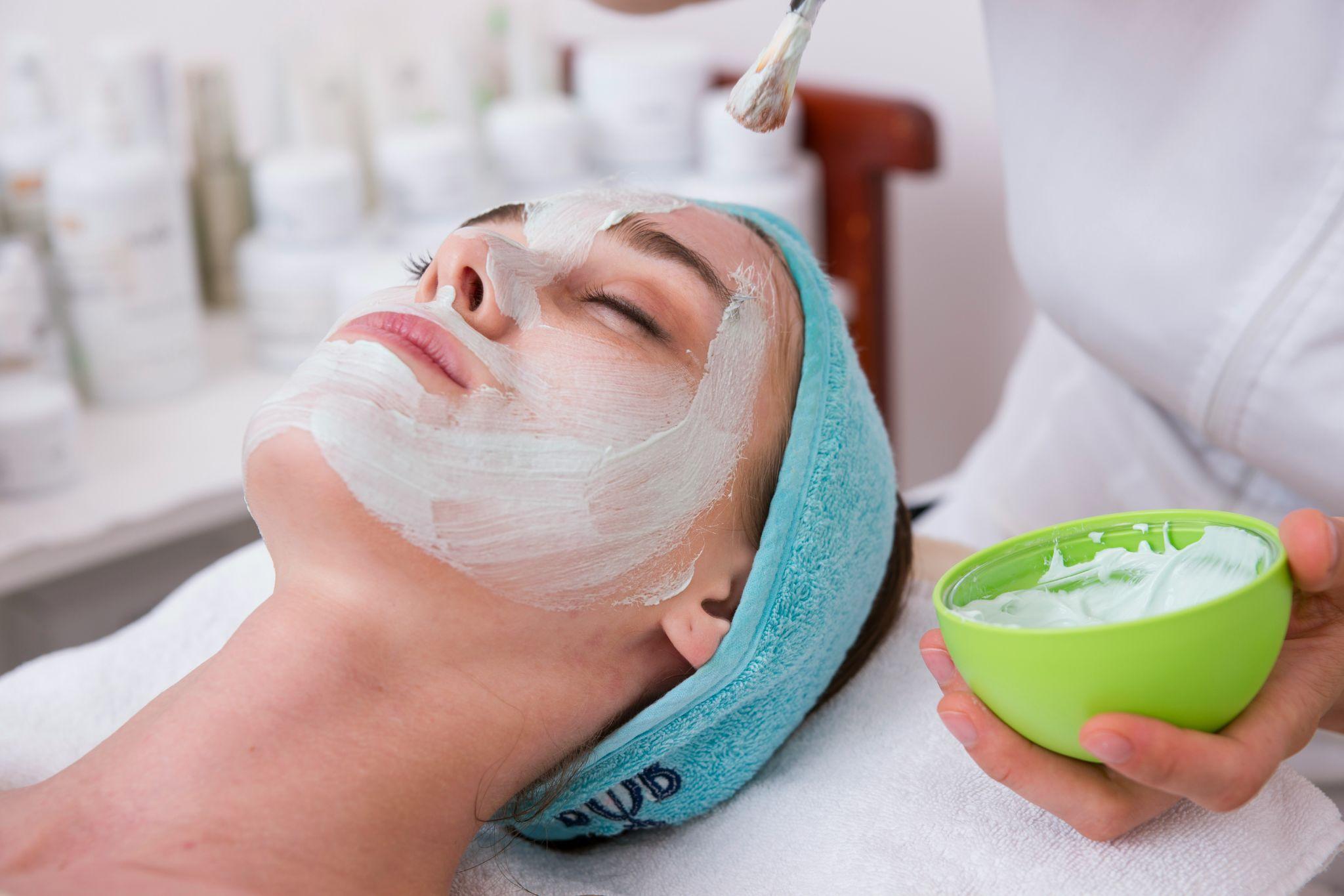 A skincare professional applies a facial mask during facial treatments in Las Vegas.