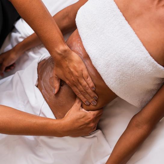 Therapist performing lymphatic drainage body sculpting in Las Vegas on a client's abdomen.